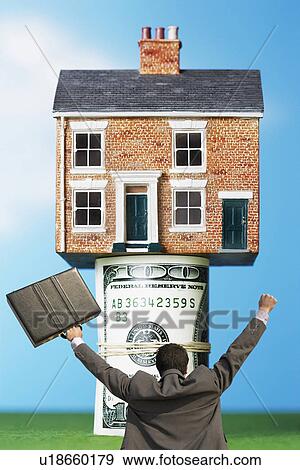 Back view of victorious businessman with briefcase in front of house on money rolls View Large Photo Image Stock Photo - Back view of victorious businessman with briefcase in front of house on money rolls. Fotosearch