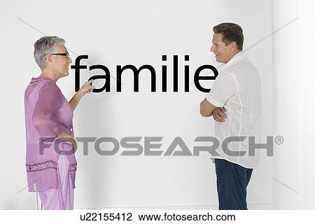 Couple discussing family issues against white wall with German text "Familie" View Large Photo Image Stock Image - Couple discussing family issues against white wall with German text "Familie". Fotosearch