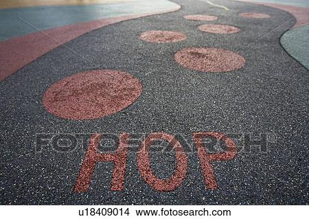 Picture - "Hop" written into rubber floor of playground. Fotosearch