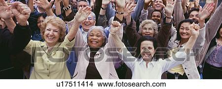Picture - Large group of multi-ethnic people cheering with arms raised. Fotosearch