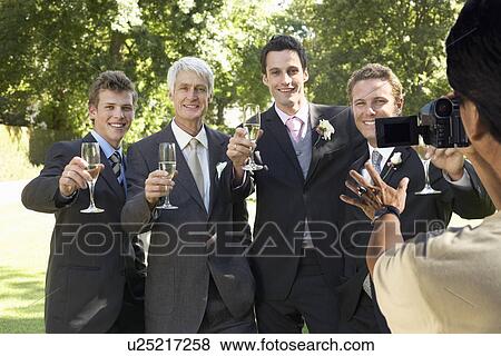 Man taking a picture of five men toasting with wine glasses at wedding party View Large Photo Image Stock Photo - Man taking a picture of five men toasting with wine glasses at wedding party. Fotosearch