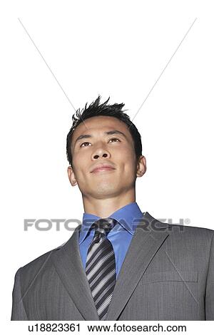 Stock Image - Mid-adult businessman smiling against white background. Fotosearch