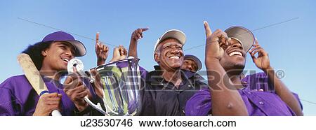 Panoramic shot of cheerful baseball players with trophy celebrating victory against clear sky View Large Photo Image Stock Photograph - Panoramic shot of cheerful baseball players with trophy celebrating victory against clear sky. Fotosearch