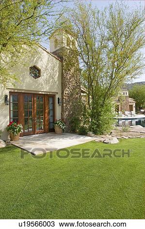 Stock Image - Patio and garden in rear of modern home. Fotosearch