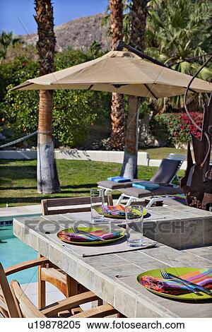 Stock Photography - Plate settings by poolside. Fotosearch