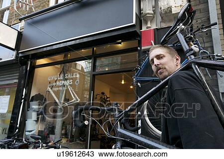 Portrait of a mid adult man carrying bicycle on shoulder View Large Photo Image Stock Image - Portrait of a mid adult man carrying bicycle on shoulder. Fotosearch