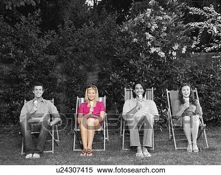 Portrait of happy young friends sitting on deck chair with ice creams in backyard View Large Photo Image Stock Photography - Portrait of happy young friends sitting on deck chair with ice creams in backyard. Fotosearch