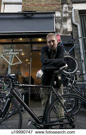 Portrait of mid adult man standing outside cycle shop View Large Photo Image Stock Photo - Portrait of mid adult man standing outside cycle shop. Fotosearch