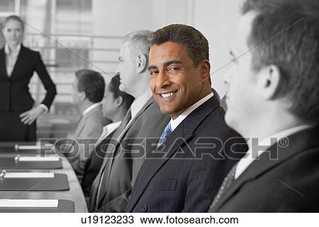 Portrait of smiling businessman in conference room with colleagues View Large Photo Image Stock Image - Portrait of smiling businessman in conference room with colleagues. Fotosearch