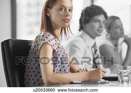 Portrait of young businesswoman with colleagues in a meeting View Large Photo Image Stock Image - Portrait of young businesswoman with colleagues in a meeting. Fotosearch