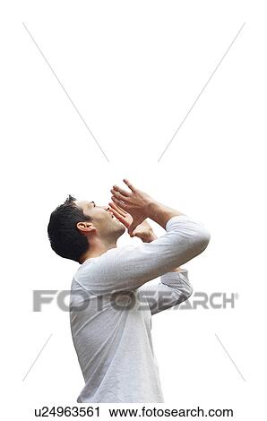 Stock Image - Profile shot of mid-adult man in casuals shouting over white background. Fotosearch