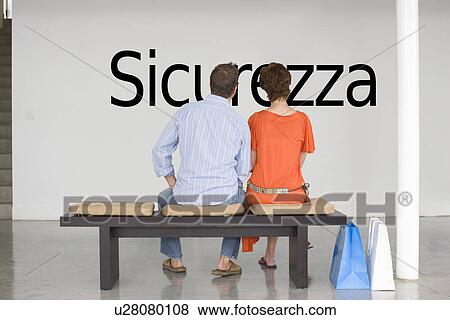 Rear view of couple reading Italian text "Sicurezza" (security) and contemplating about future security View Large Photo Image Stock Photo - Rear view of couple reading Italian text "Sicurezza" (security) and contemplating about future security. Fotosearch