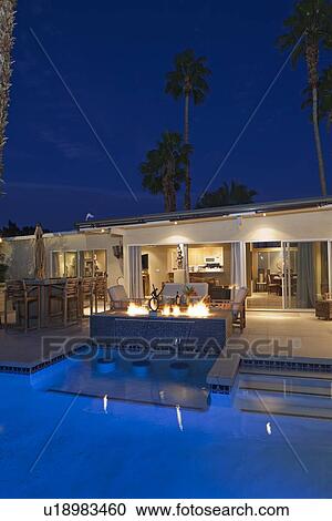 Rear view of luxury villa at night time with lit fire View Large Photo Image Stock Image - Rear view of luxury villa at night time with lit fire. Fotosearch