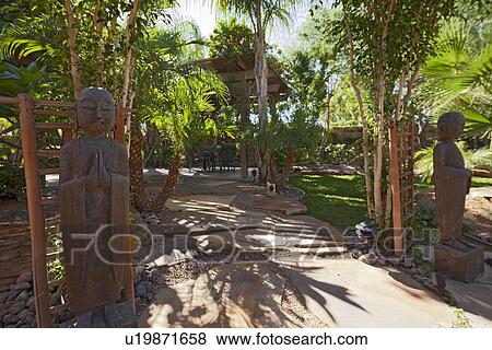 Stock Photo - Relaxing garden with Buddhist statues. Fotosearch