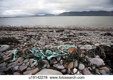 Stock Photo - Rubbish on shore with water in background. Fotosearch