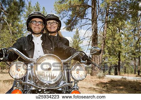 Senior couple riding motorcycle through a forest View Large Photo Image Stock Image - Senior couple riding motorcycle through a forest. Fotosearch
