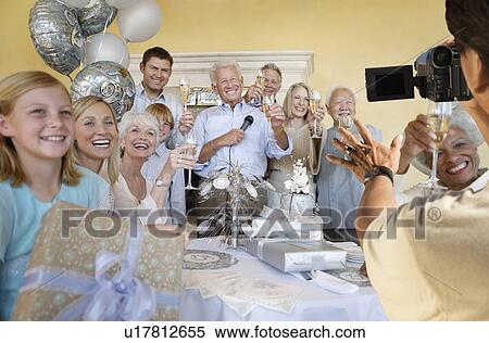 Stock Photography - Senior man celebrating start of retirement with family and friends. Fotosearch