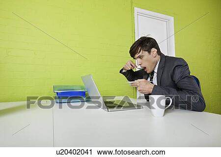 Side view of young businessman eating while using laptop at table View Large Photo Image Stock Image - Side view of young businessman eating while using laptop at table. Fotosearch