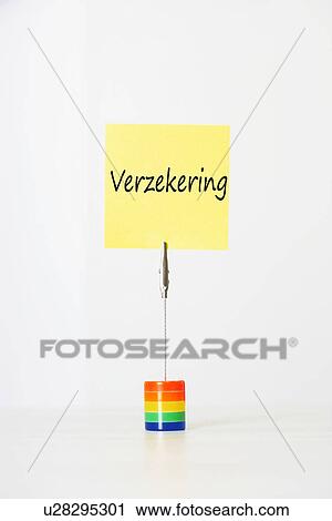 Stock Image - Sticky notepaper with Dutch text "Verzekering" (Insurance) clipped to a multicolored card holder. Fotosearch