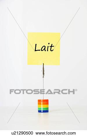 Stock Image - Sticky notepaper with French text meaning "Lait" (milk) clipped to a multicolored card holder. Fotosearch