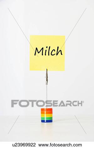Stock Image - Sticky notepaper with German text "Milch" (milk) clipped to a multicolored card holder. Fotosearch
