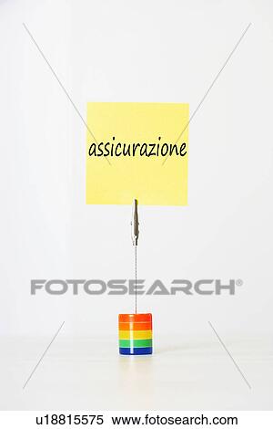Stock Photography - Sticky notepaper with Italian text "assicurazione" (Insurance) clipped to a multicolored card holder. Fotosearch