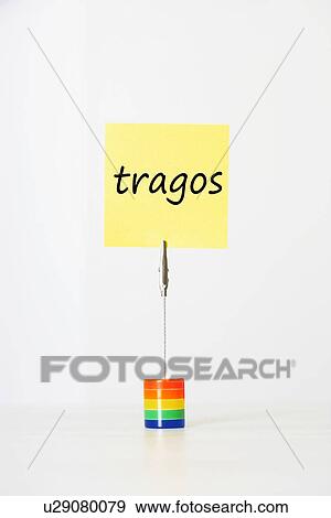 Stock Photo - Sticky notepaper with Spanish text "Tragos" (Drinks) clipped to a multicolored card holder. Fotosearch