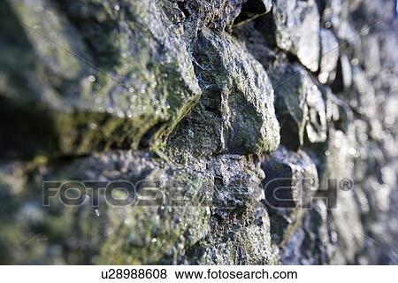Stock Photo - Stone wall glints in sunlight. Fotosearch