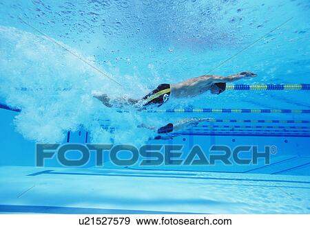 Underwater shot of three male athletes racing in swimming pool View Large Photo Image Stock Photo - Underwater shot of three male athletes racing in swimming pool. Fotosearch