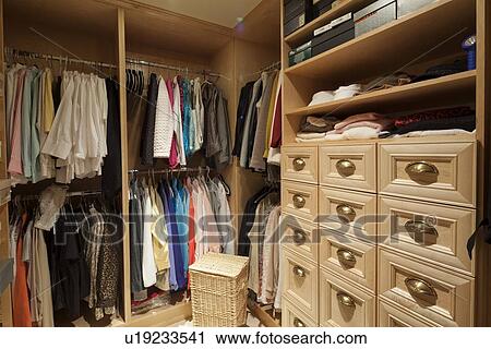 Stock Image - Walk in closet with organized clothing. Fotosearch