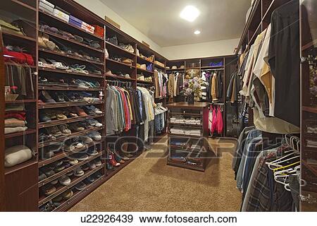 Walk in closet with organized clothing View Large Photo Image Stock Photo - Walk in closet with organized clothing. Fotosearch