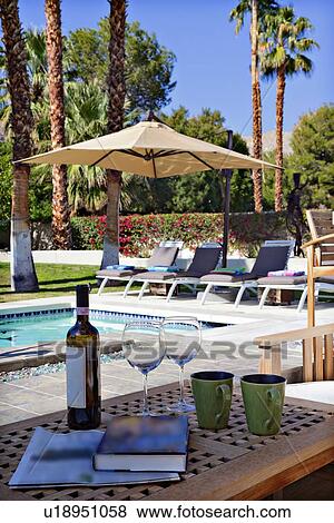 Stock Photo - Wine and wineglasses by poolside. Fotosearch