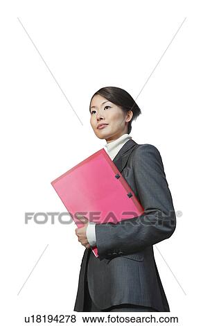 Stock Photo - Young businesswoman with pink file standing against white background. Fotosearch