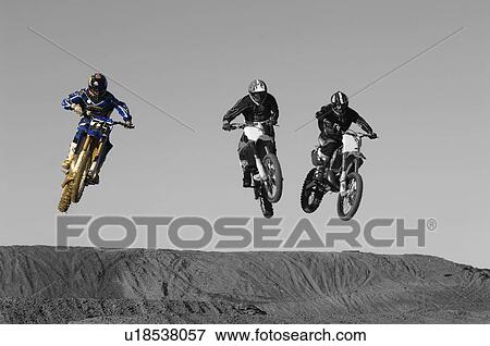 Stock Photo - Young motocross racers riding on dirt track. Fotosearch