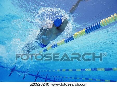 Stock Image - Young professional male athlete doing backstroke in swimming pool. Fotosearch