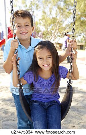 Boy And Girl Playing On Swing In Park View Large Photo Image Picture - Boy And Girl Playing On Swing In Park. Fotosearch