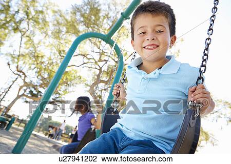 Boy And Girl Playing On Swing In Park View Large Photo Image Stock Image - Boy And Girl Playing On Swing In Park. Fotosearch