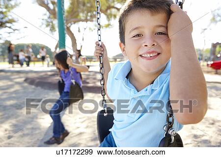 Boy And Girl Playing On Swing In Park View Large Photo Image Stock Photo - Boy And Girl Playing On Swing In Park. Fotosearch