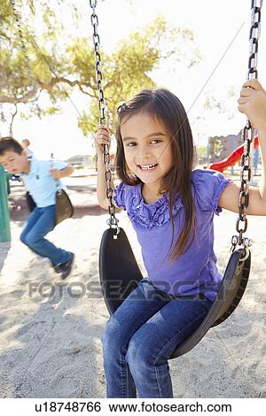 Boy And Girl Playing On Swing In Park View Large Photo Image Stock Photograph - Boy And Girl Playing On Swing In Park. Fotosearch