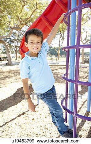 Stock Photo - Boy On Climbing Frame In Park. Fotosearch