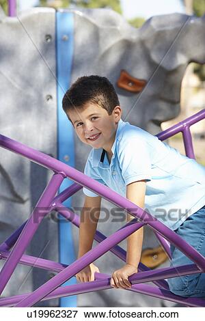 Stock Photo - Boy On Climbing Frame In Park. Fotosearch