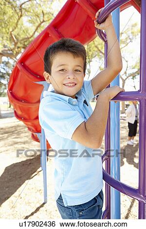 Stock Photograph - Boy On Climbing Frame In Park. Fotosearch