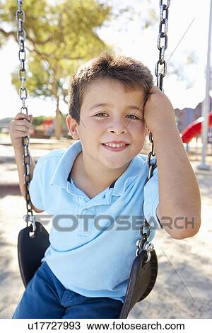 Stock Image - Boy On Swing In Park. Fotosearch