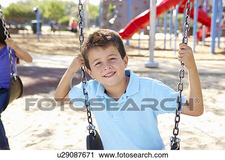 Stock Image - Boy On Swing In Park. Fotosearch