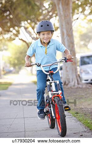 Picture - Boy Wearing Safety Helmet Riding Bike. Fotosearch