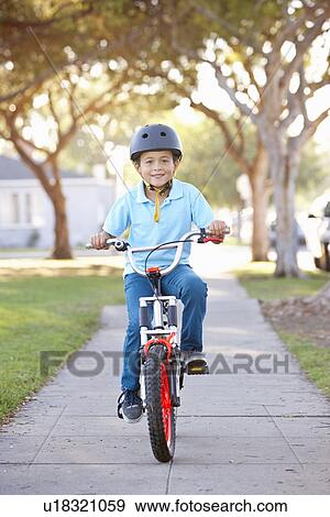 Stock Photo - Boy Wearing Safety Helmet Riding Bike. Fotosearch