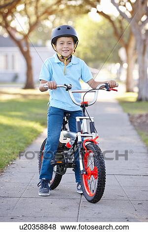 Stock Photo - Boy Wearing Safety Helmet Riding Bike. Fotosearch