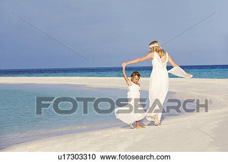Stock Image - Bride With Bridesmaid At Beautiful Beach Wedding. Fotosearch