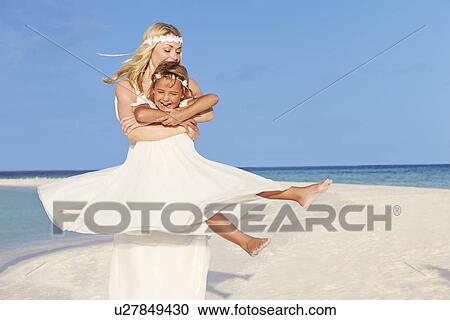 Stock Image - Bride With Bridesmaid At Beautiful Beach Wedding. Fotosearch