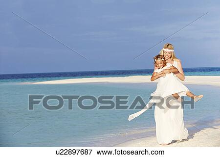 Stock Photo - Bride With Bridesmaid At Beautiful Beach Wedding. Fotosearch